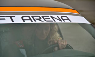Donna alla guida di una BMW con un adesivo sul parabrezza che dice "DRIFT ARENA".